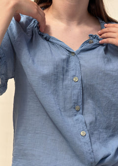 Détail de l'encolure froncée et du boutonnage nacré de la blouse Capucine en voile de coton bleu, Dune & Coton — Couleur: Bleu jean