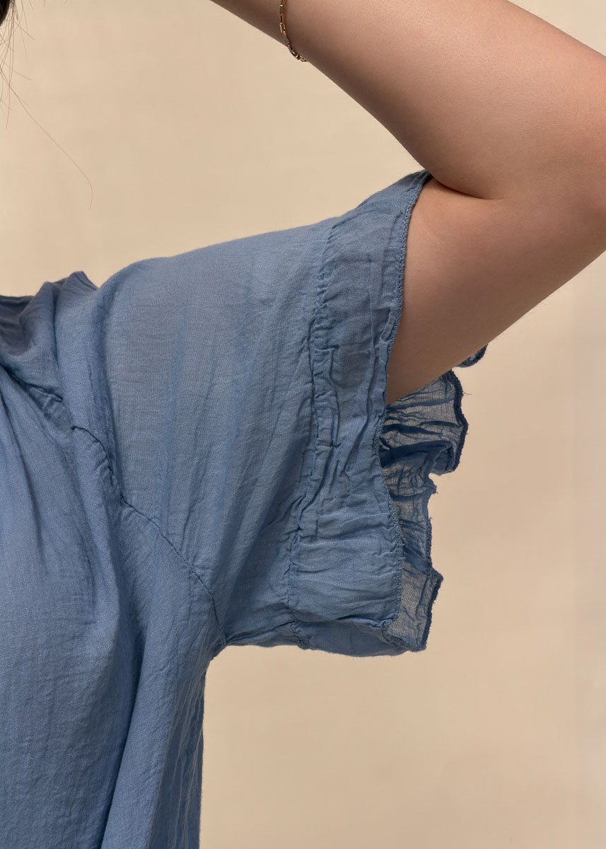 Détail de la manche courte à volant de la blouse Capucine en voile de coton bleu, Dune & Coton — Couleur: Bleu jean