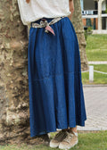 Jupe longue en jean femme, coupe évasée et fluide, portée de profil avec foulard noué à la taille, Dune & Coton — Couleur: Denim Blue