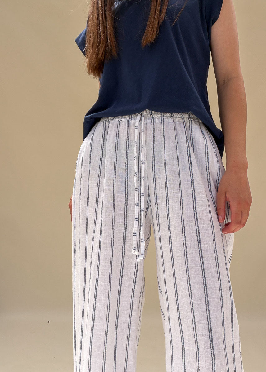 Détail de la taille élastique à cordon d'un pantalon large en lin blanc rayé bleu femme, gros plan sur la ceinture, esprit côtier Le Touquet-Paris-Plage Dune & Coton — Couleur: Marine