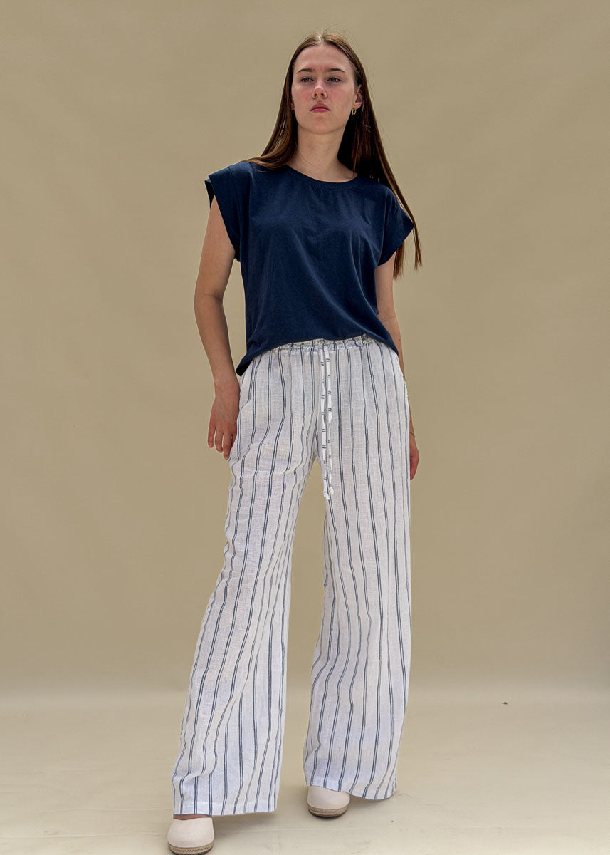 Pantalon large femme en lin blanc à rayures bleues, taille élastique à cordon, jambe ample et fluide, vue de face en pied, allure balnéaire chic Dune & Coton — Couleur: Marine
