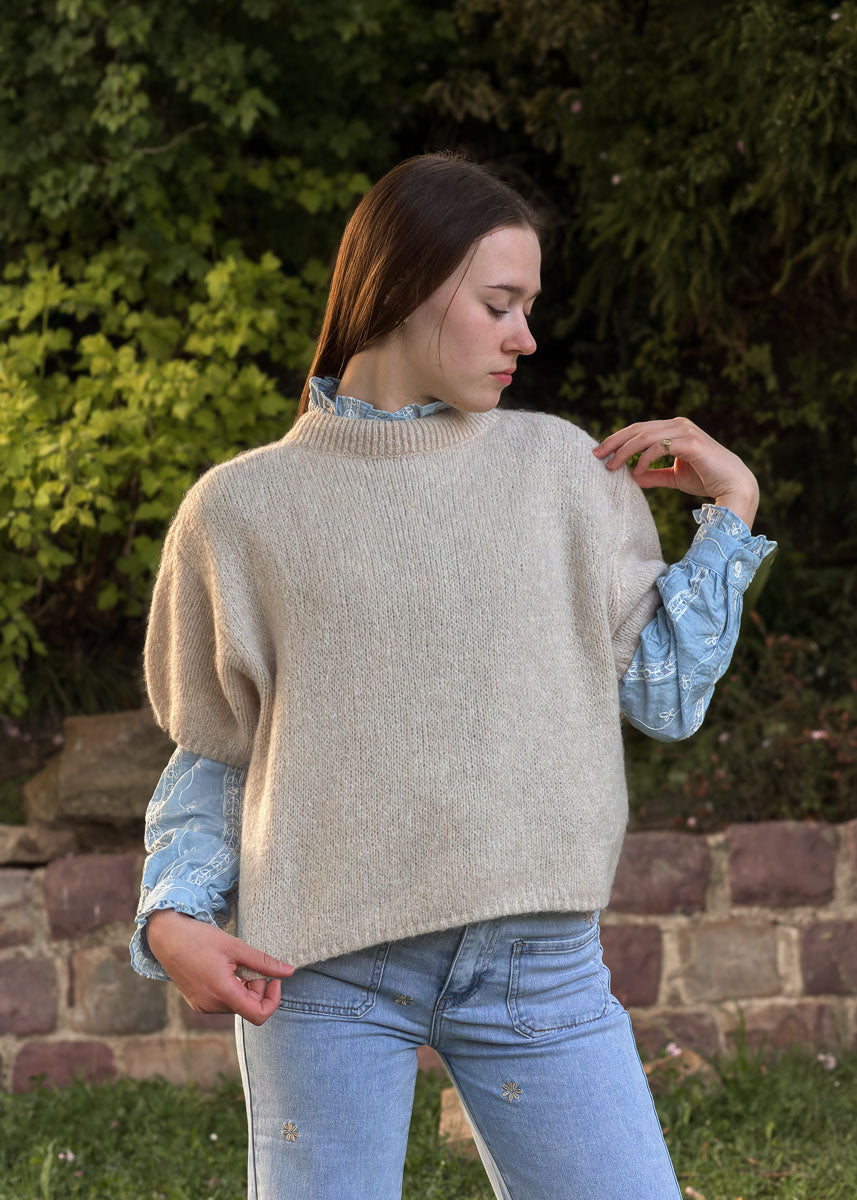 Pull femme en maille beige, col montant et coupe ample, porté de profil, Dune & Coton — Couleur: Beige
