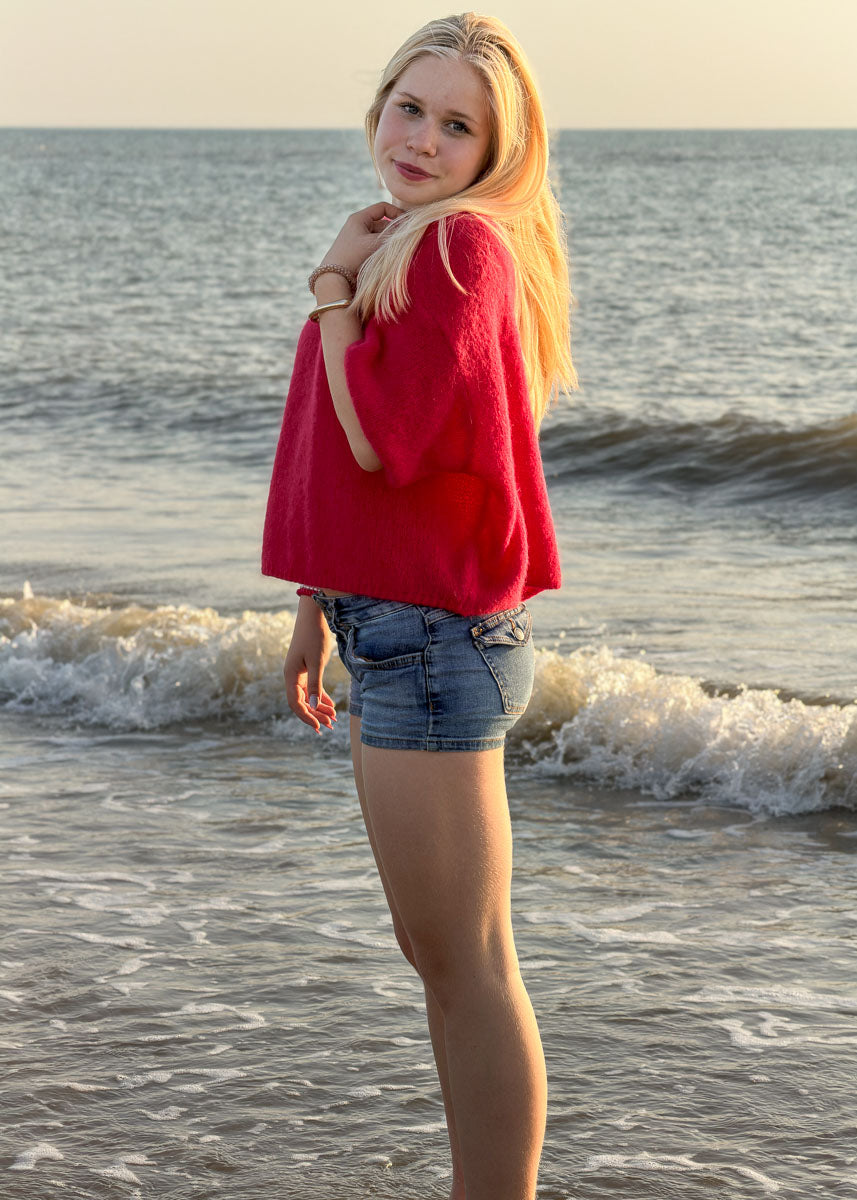 Pull femme en maille rouge cerise à manches courtes, coupe ample, porté au bord de mer, Dune & Coton — Couleur: Rouge Cerise