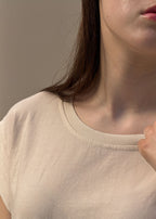 Détail du col rond et de la finition d'encolure surpiquée d'un t-shirt en coton crème femme, gros plan sur la maille jersey souple, Dune & Coton — Couleur: Crème