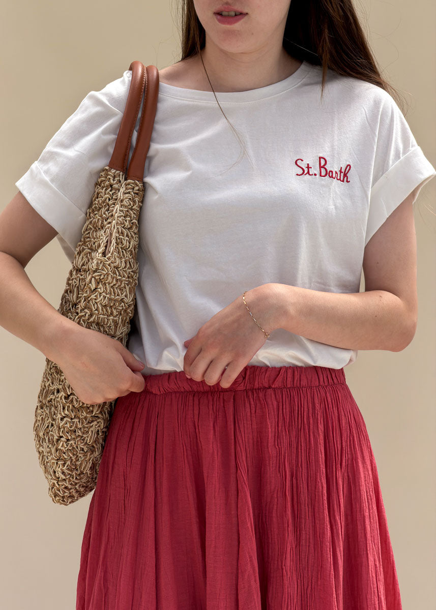 T-shirt femme en coton blanc à broderie St. Barth rouge dans le dos, col rond et manches courtes à revers, porté de dos en extérieur, allure balnéaire chic Dune & Coton — Couleur: Blanc