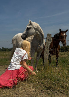 T-shirt femme en coton blanc à broderie St. Barth rouge dans le dos, col rond et manches courtes à revers, porté de dos en extérieur, allure balnéaire chic Dune & Coton — Couleur: Blanc